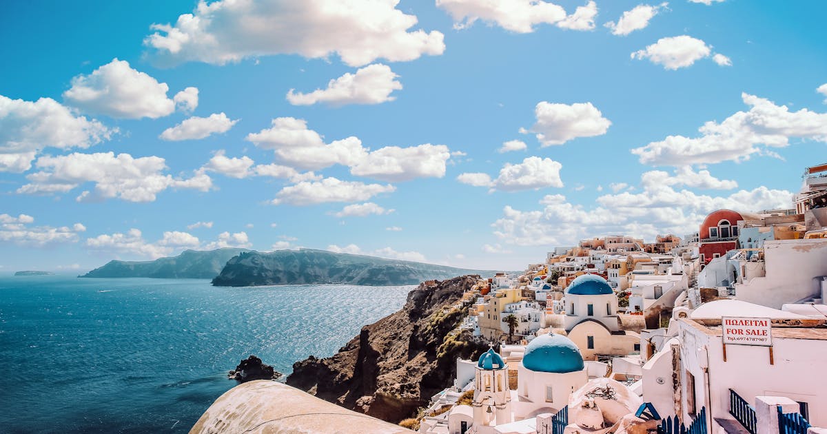 Ndërtesat ikonike me kupola blu të Santorinit, Greqi, nën diellin mesdhetar