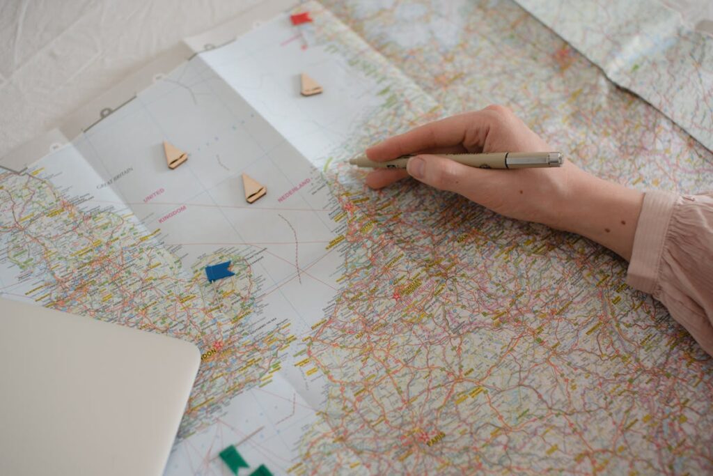 Hand with pen planning travel route on a Europe map — ETIAS application planning