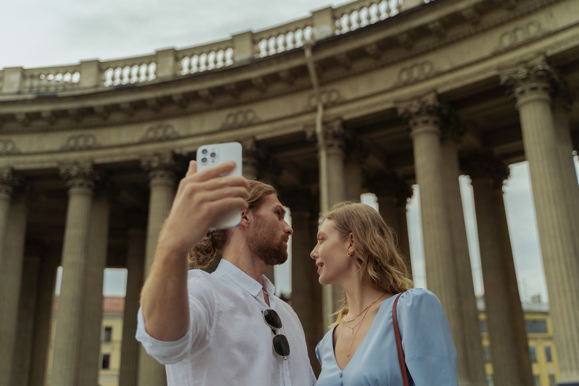 couple at European landmark, smiling, travel documents in pocket