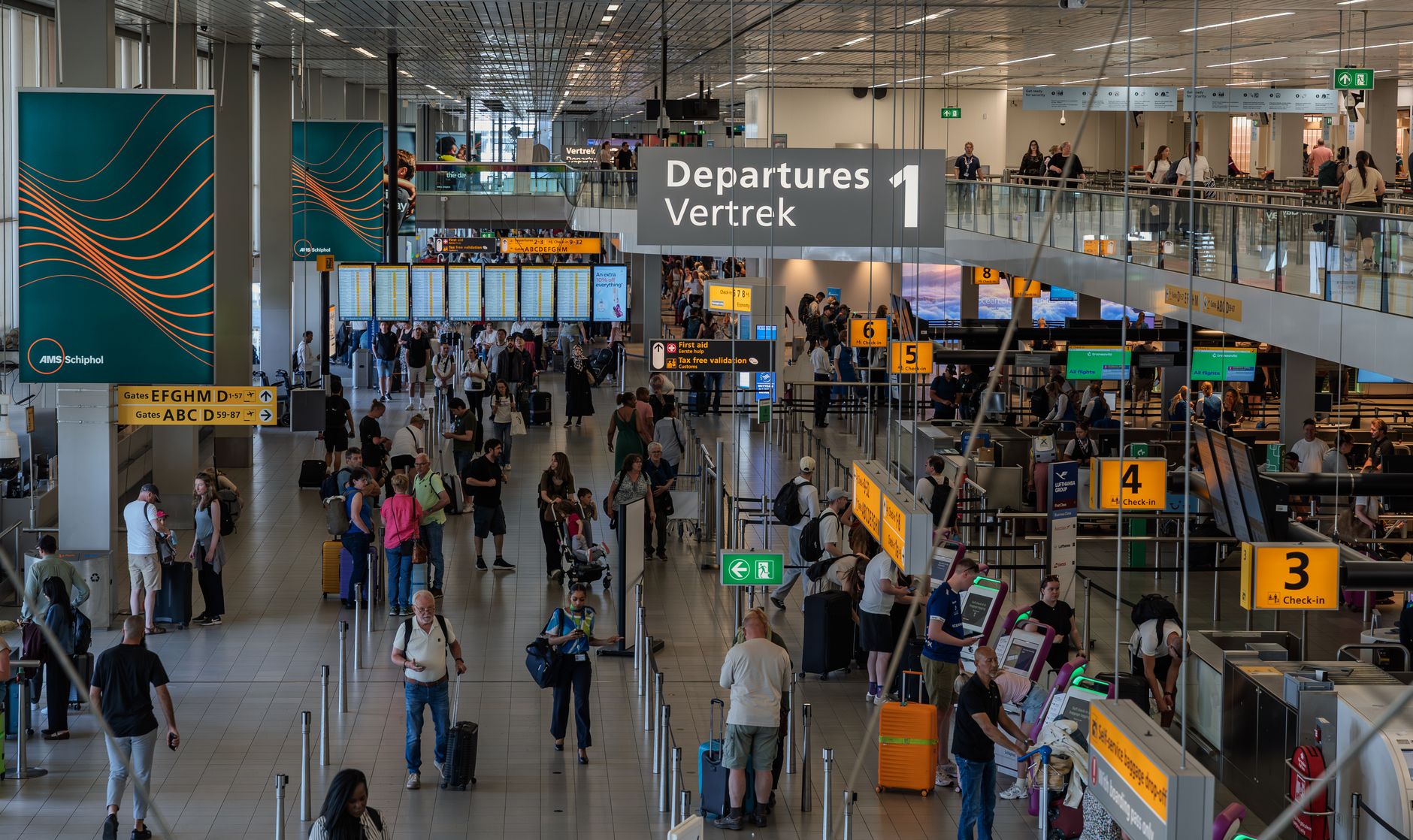 Busy airport departure hall packed with travellers and luggage in summer