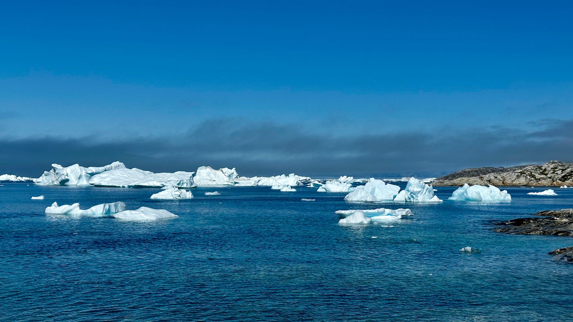 Arctic coastline with floating sea ice near a remote Greenland settlement