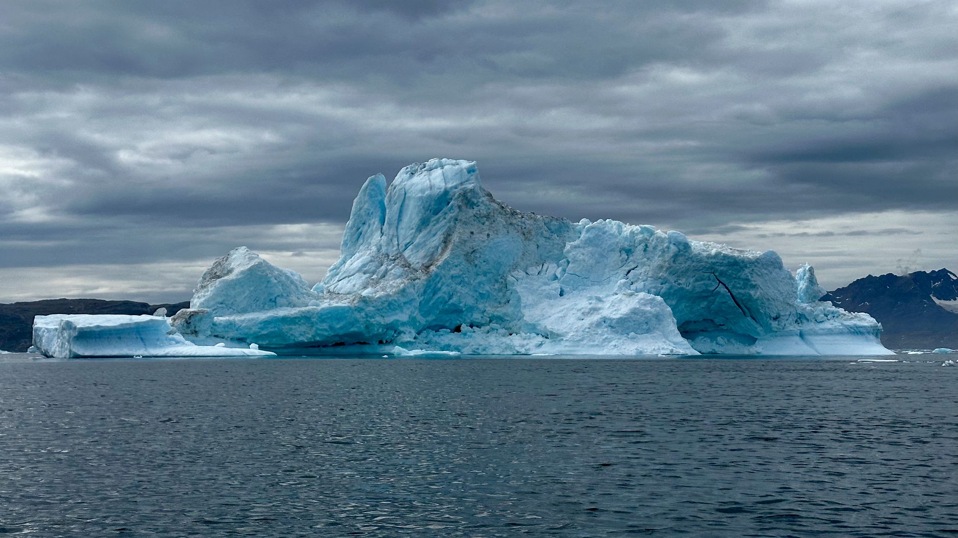 Dramatic Greenland glacier and iceberg scenery under bright summer daylight