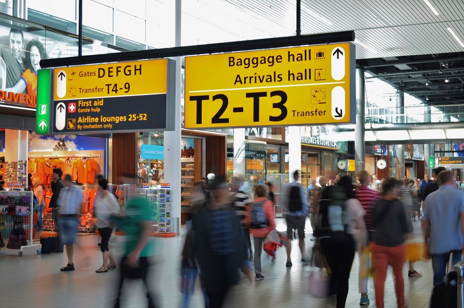 Passengers walking through a European airport terminal during a connecting flight layover