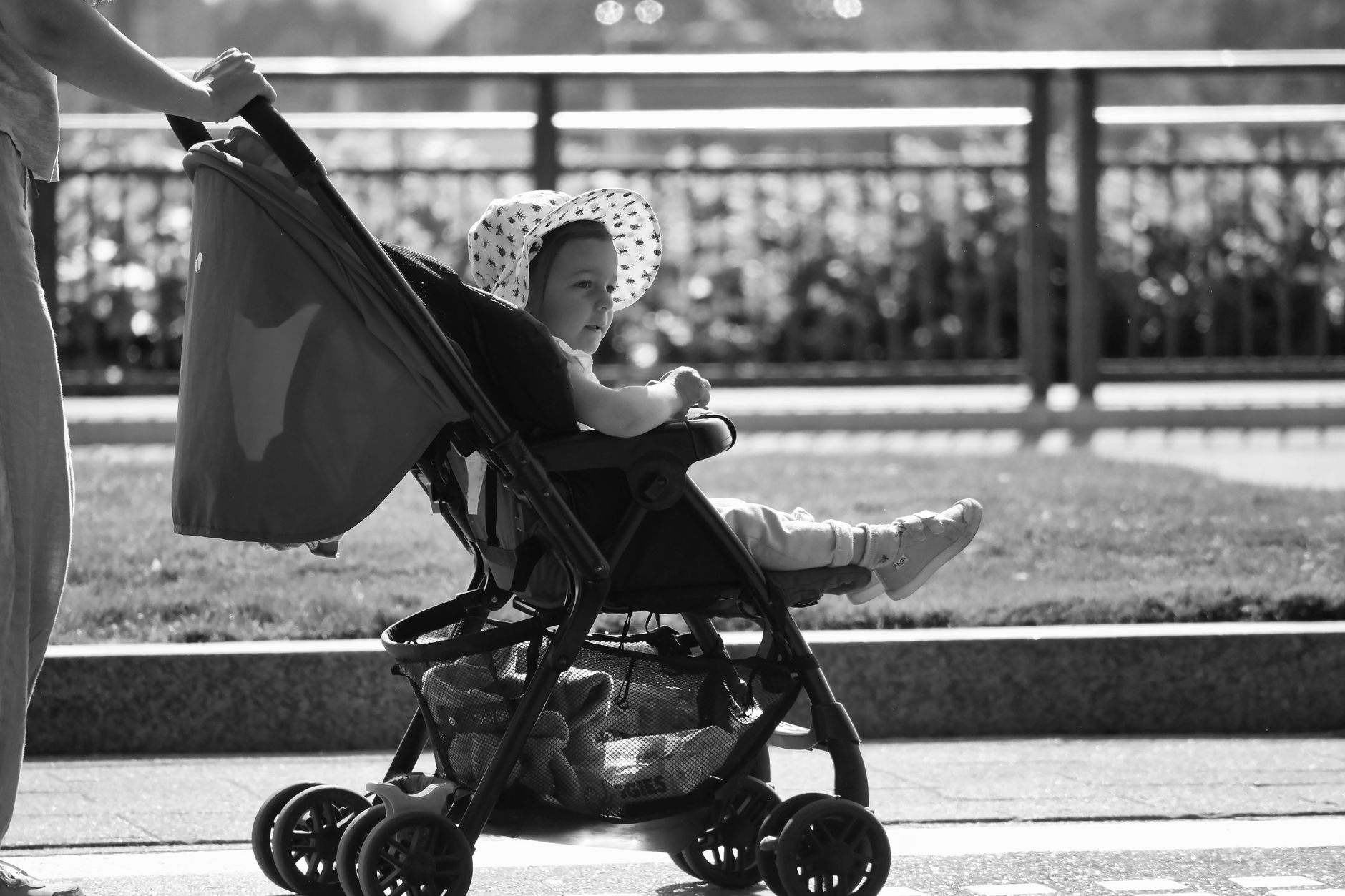 Parents pushing a toddler in a stroller through an airport arrivals hall