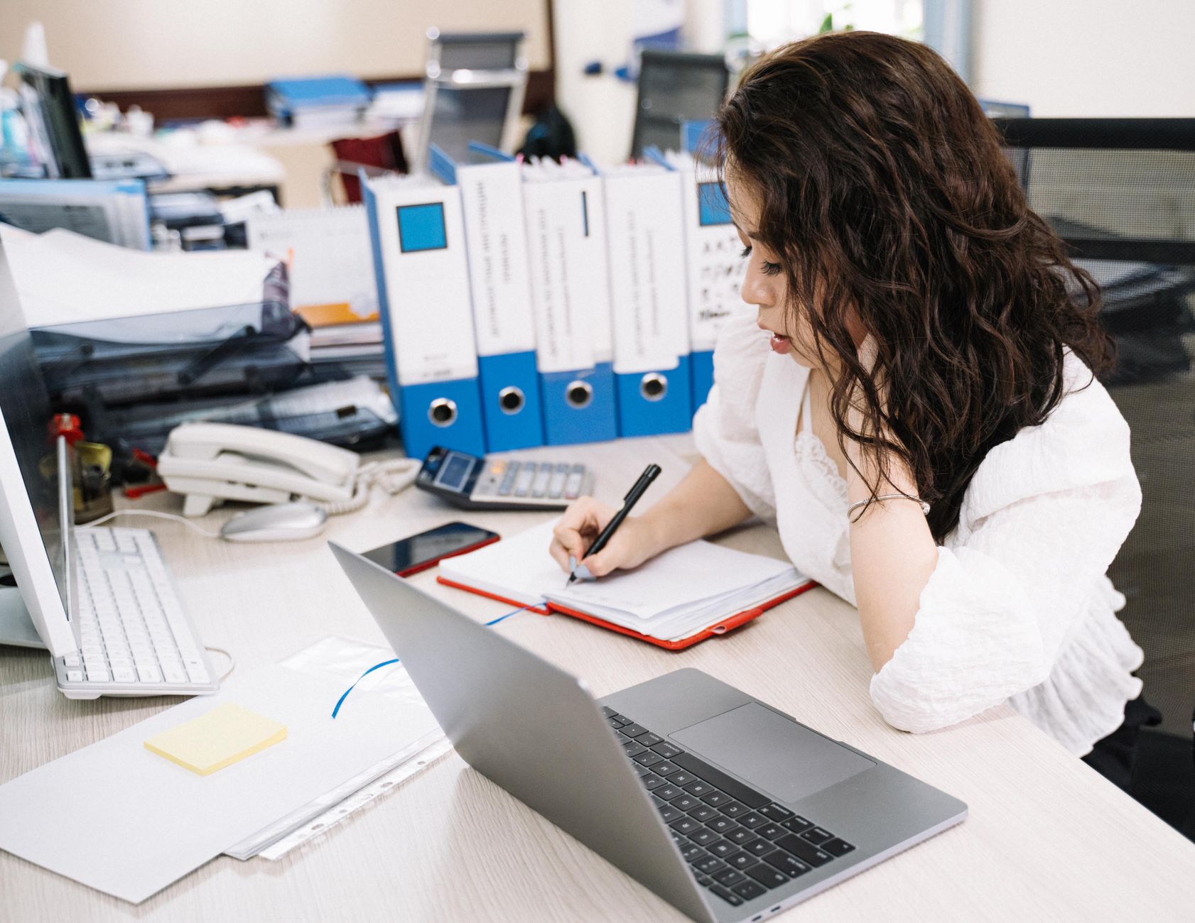 Person reviewing travel paperwork and boarding passes at a desk with a laptop