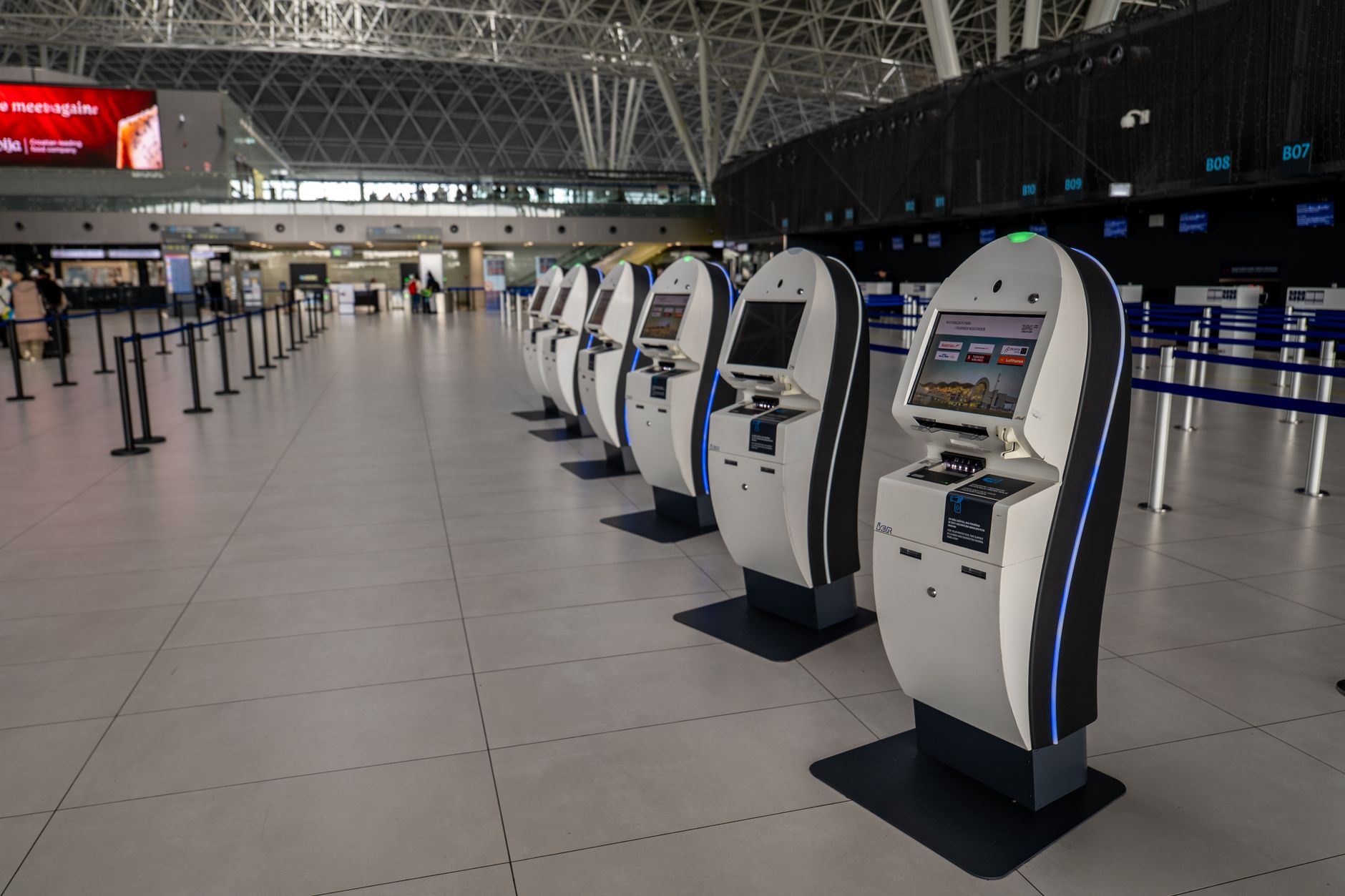 Row of self-service passport kiosks with cameras in an airport arrivals area