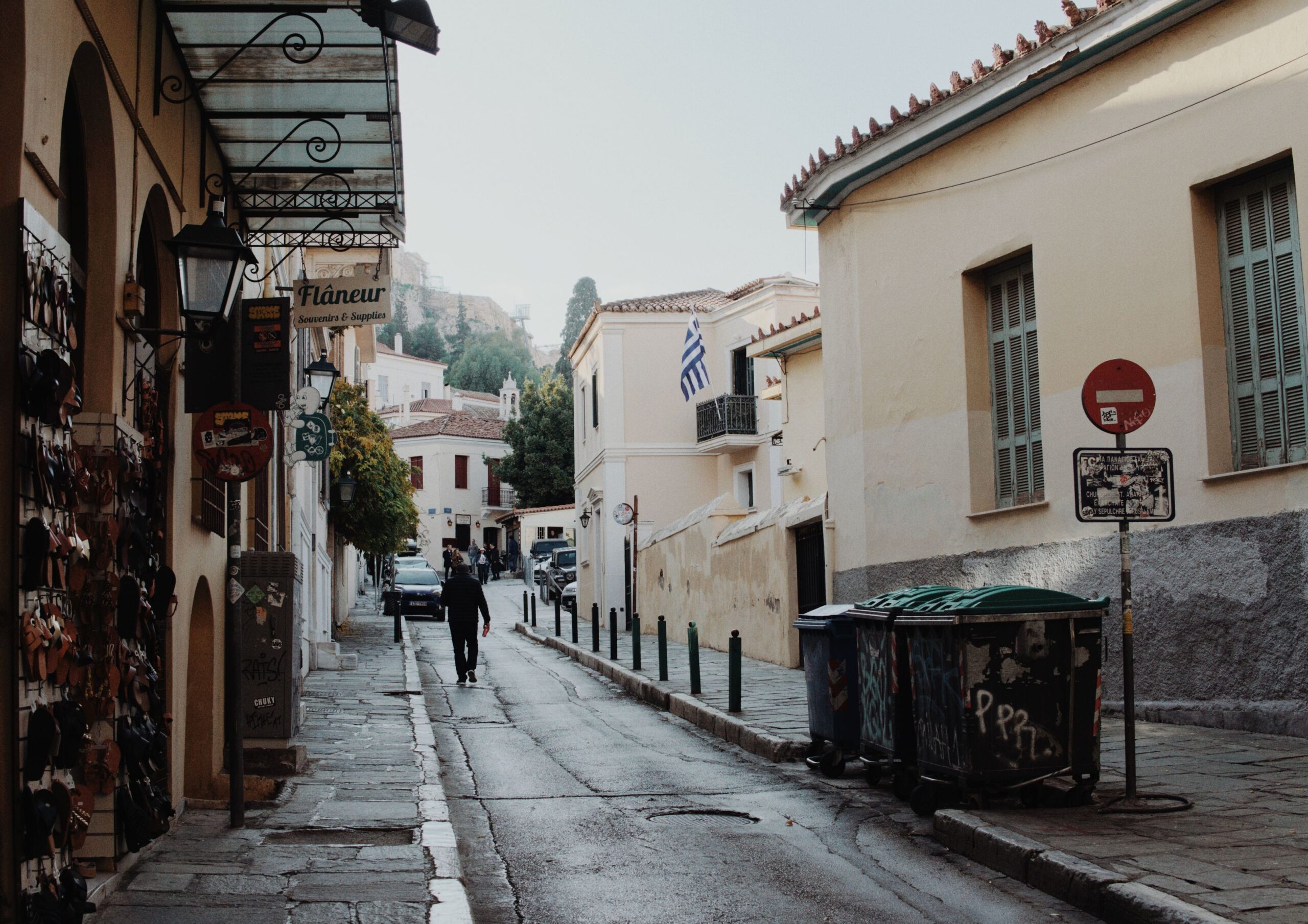 Quiet street in the historic Plaka district of Athens with Greek flags