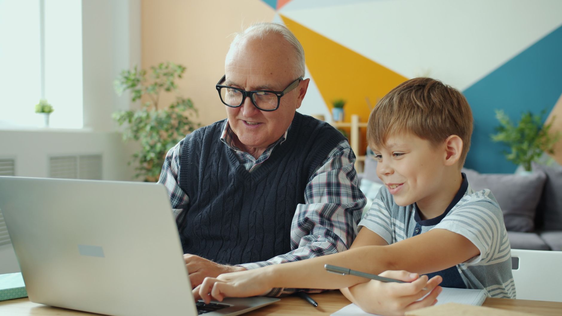 Adult daughter helping her elderly mother complete an online travel form on a laptop