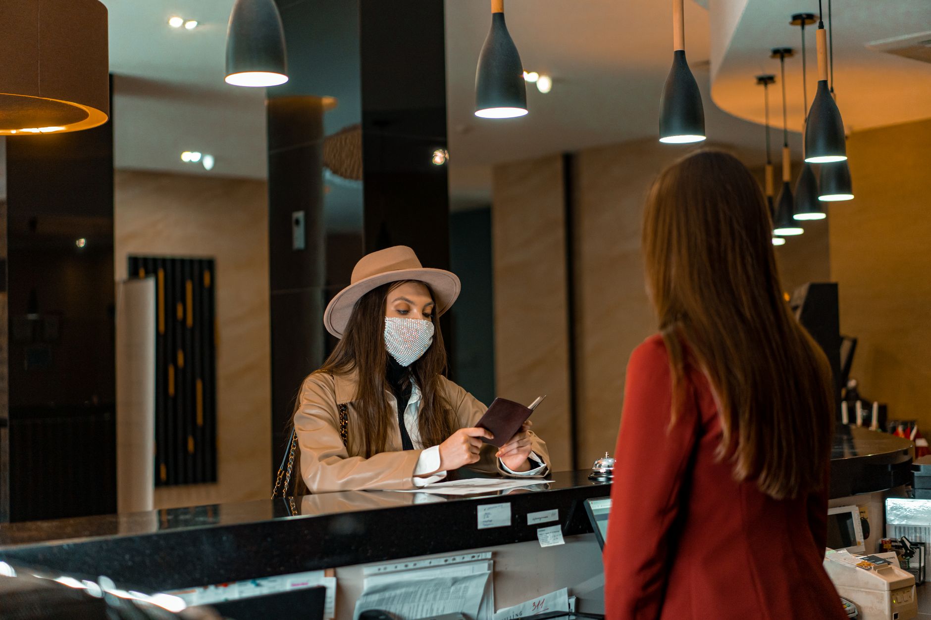 Travel agent at a desk filing an application for a client holding a passport