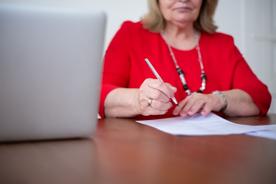 Close-up of hands typing passport details into an online application form