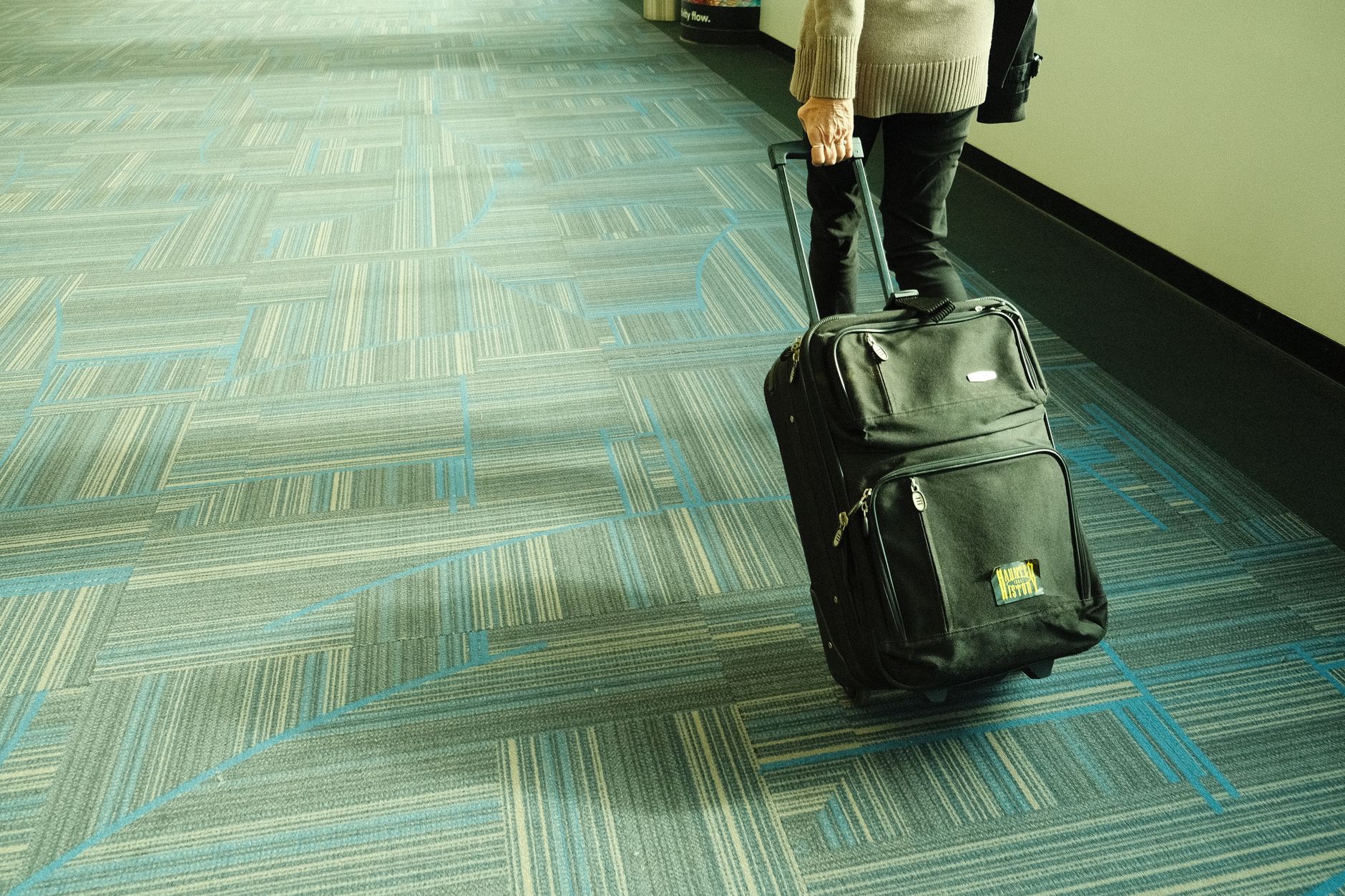 Traveller walking with luggage to a connecting gate, deciding whether ETIAS for a layover applies to their nationality